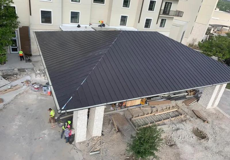 Metal roofing installation team working on a commercial building in Tequesta